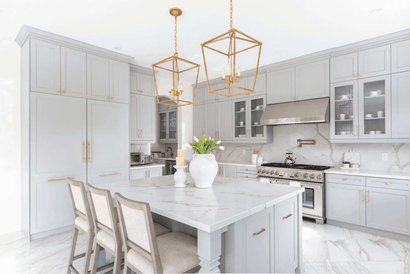 Renovation showcasing a kitchen island with three chairs in front and decorative lighting on top.